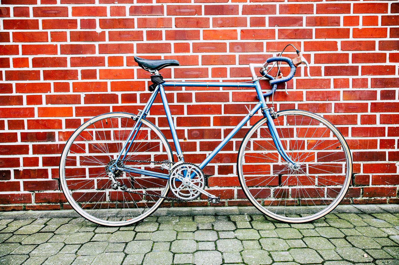 Vintage bike resting against a brick wall Vintage bike resting against a brick wall
