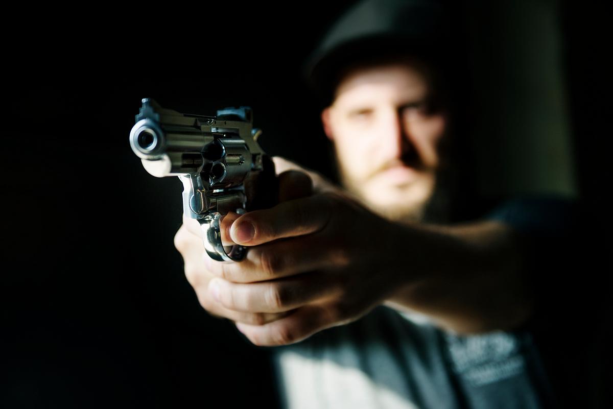 Man holding a gun with black background | Royalty free stock photo - 50084