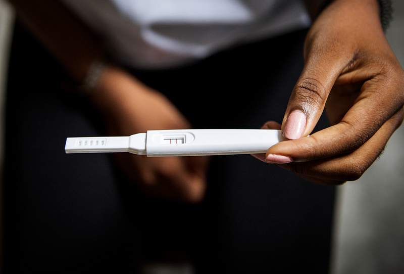 Pregnant Black Woman Holding Positive Pregnancy Test - pregnancy test