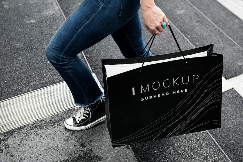 Download Woman carrying a shopping bag mockup