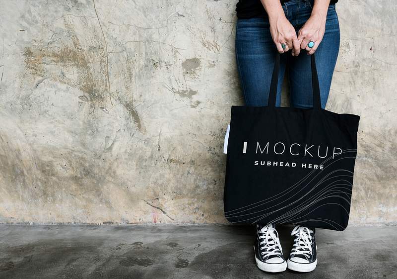 Download Woman carrying a black tote bag mockup