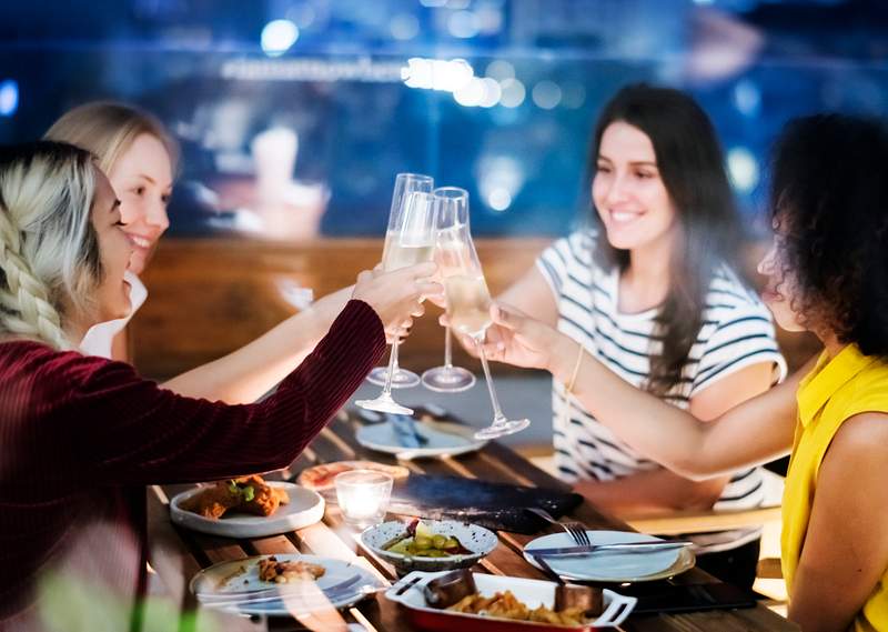 How To Increase Wine Sales In Restaurants - 10 Practical Tips 5 Girl friends toasting at dinner together at a rooftop bar