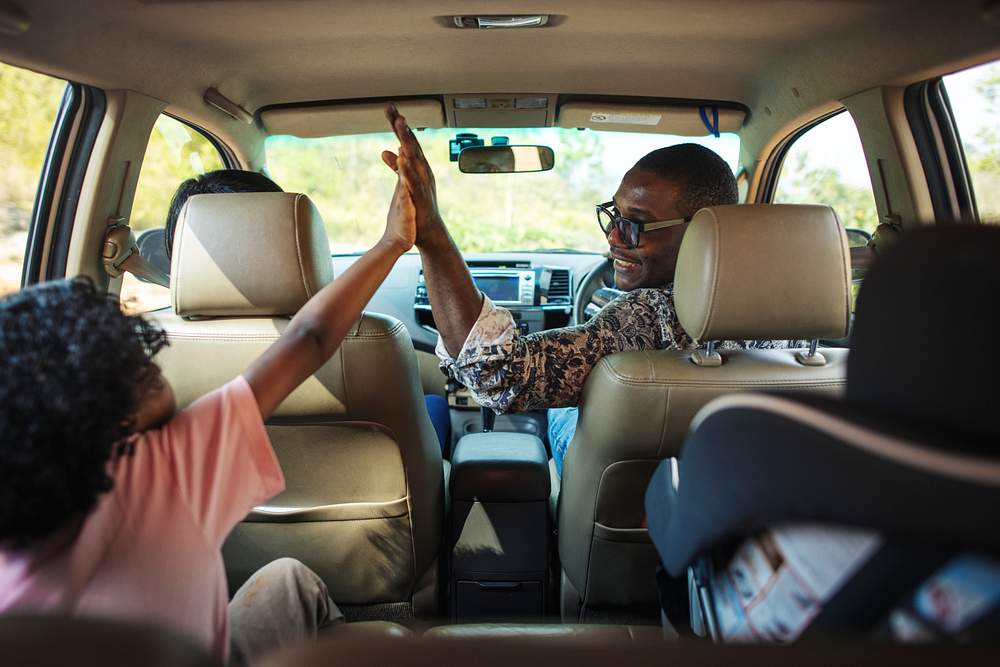 Cheerful family in a car on a road trip 