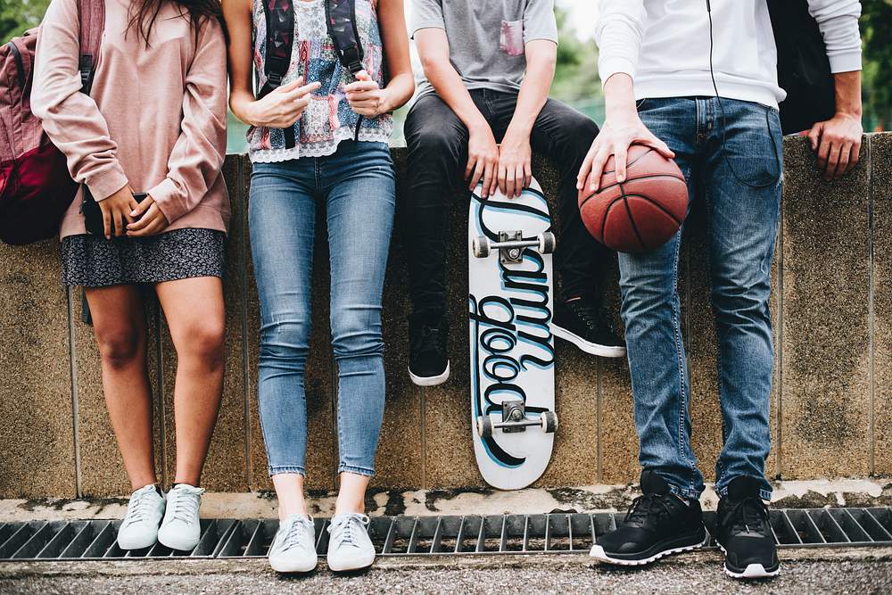 Teen friends in a row hanging out 