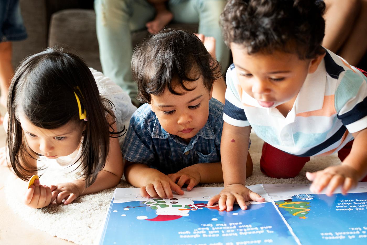 Image by Rawpixel of preschool children looking at a story book.