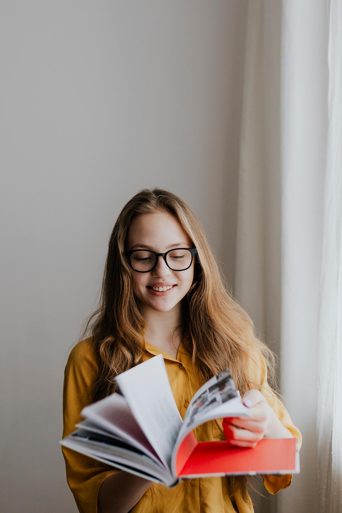 Cheerful blond girl opening a book | Premium Photo - rawpixel