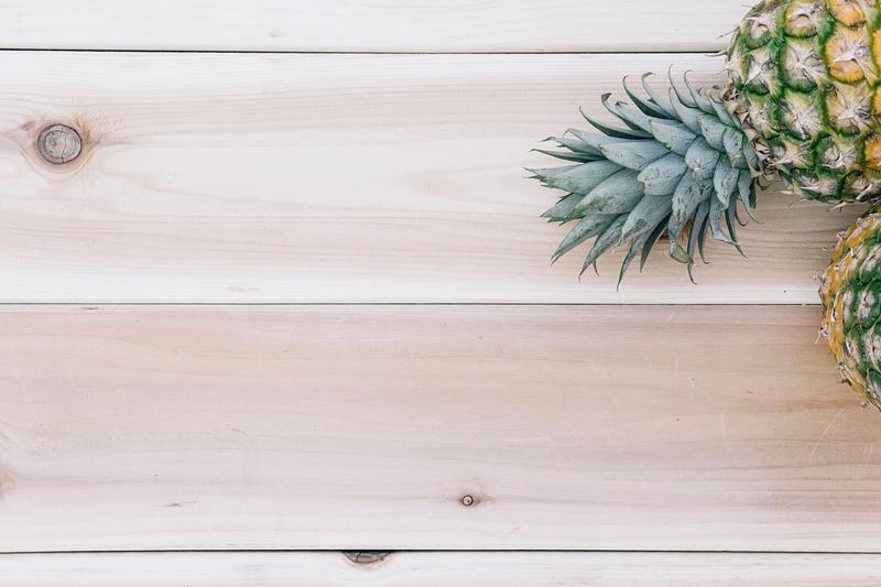 Pineapple on wooden table with design space Pineapple on wooden table with design space
