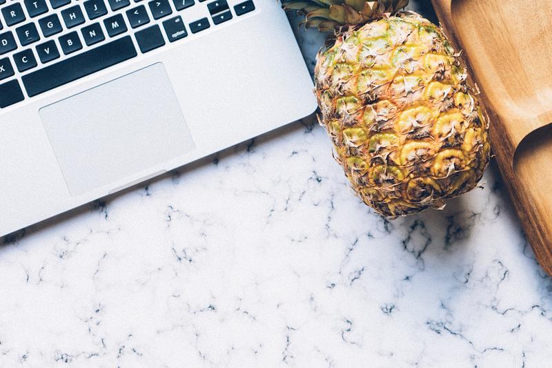 Pineapple next to a laptop Pineapple next to a laptop