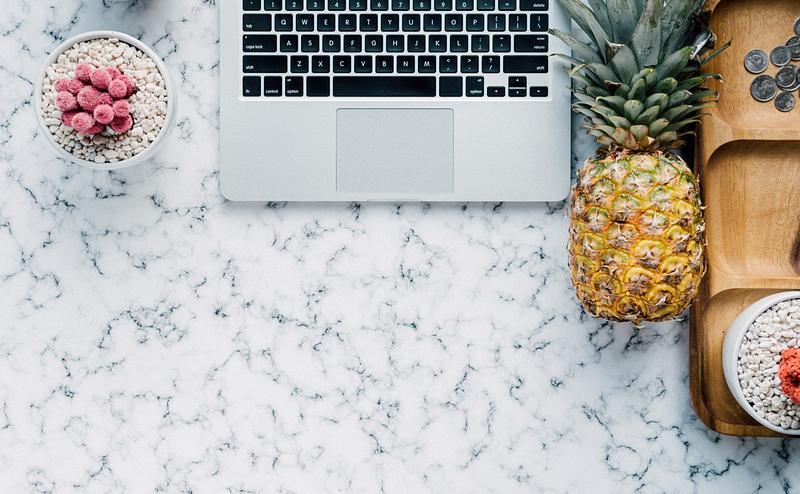 Pineapple next to a laptop Pineapple next to a laptop