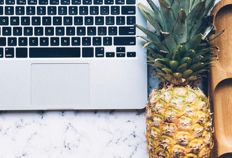 Pineapple next to a laptop Pineapple next to a laptop