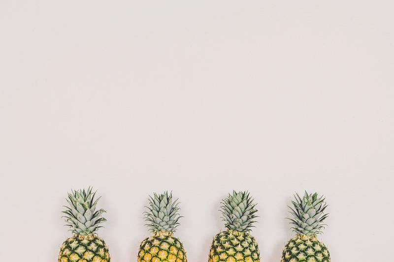 Four ripe pineapples aligned together Four ripe pineapples aligned together