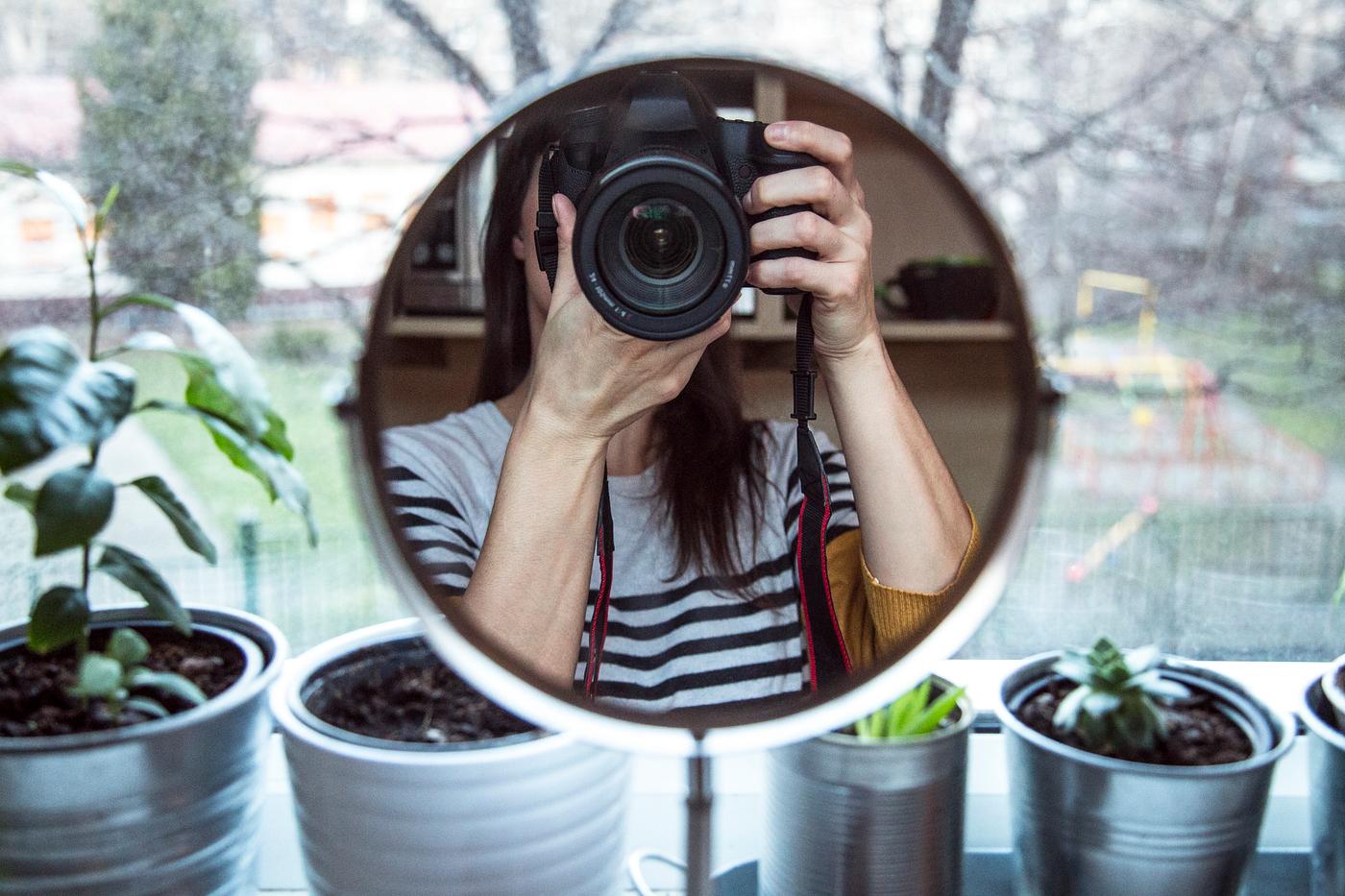 Woman taking a mirror selfie of her camera