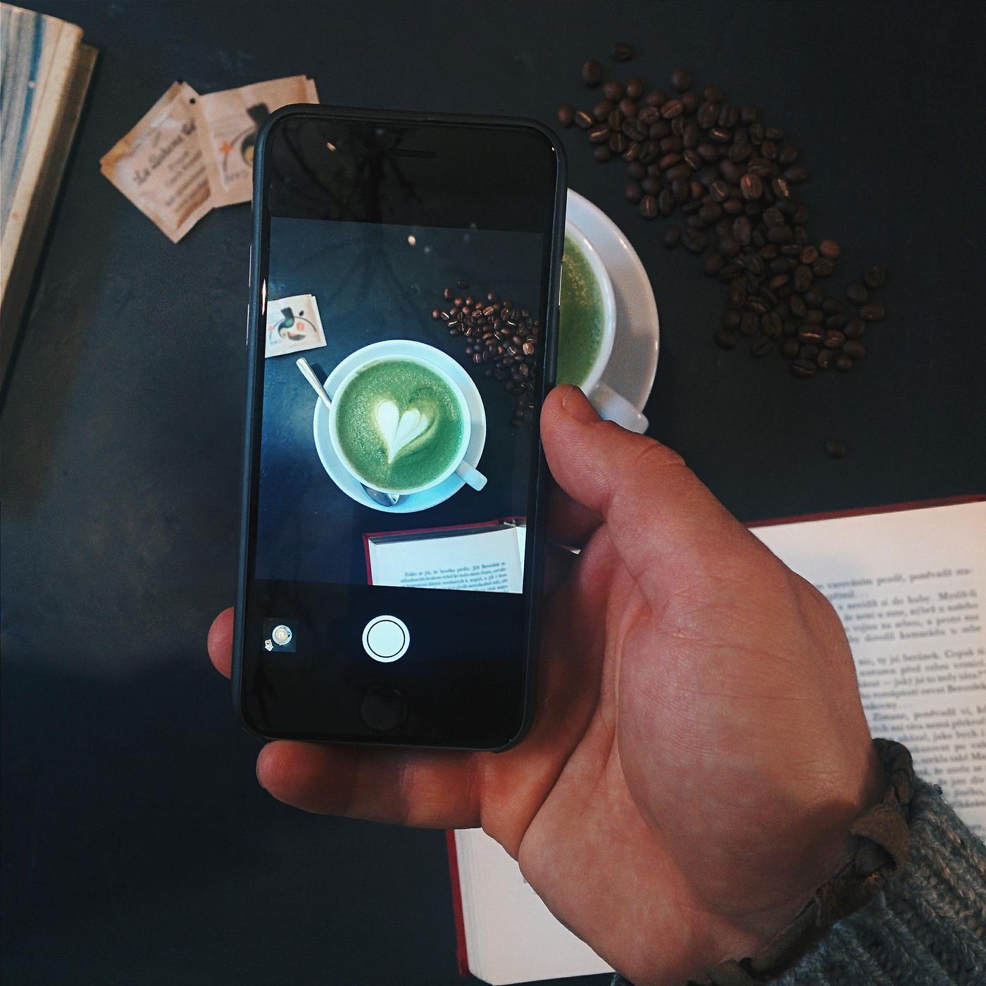 Man capturing an image of a Matcha latte with smartphone Man capturing an image of a Matcha latte with smartphone