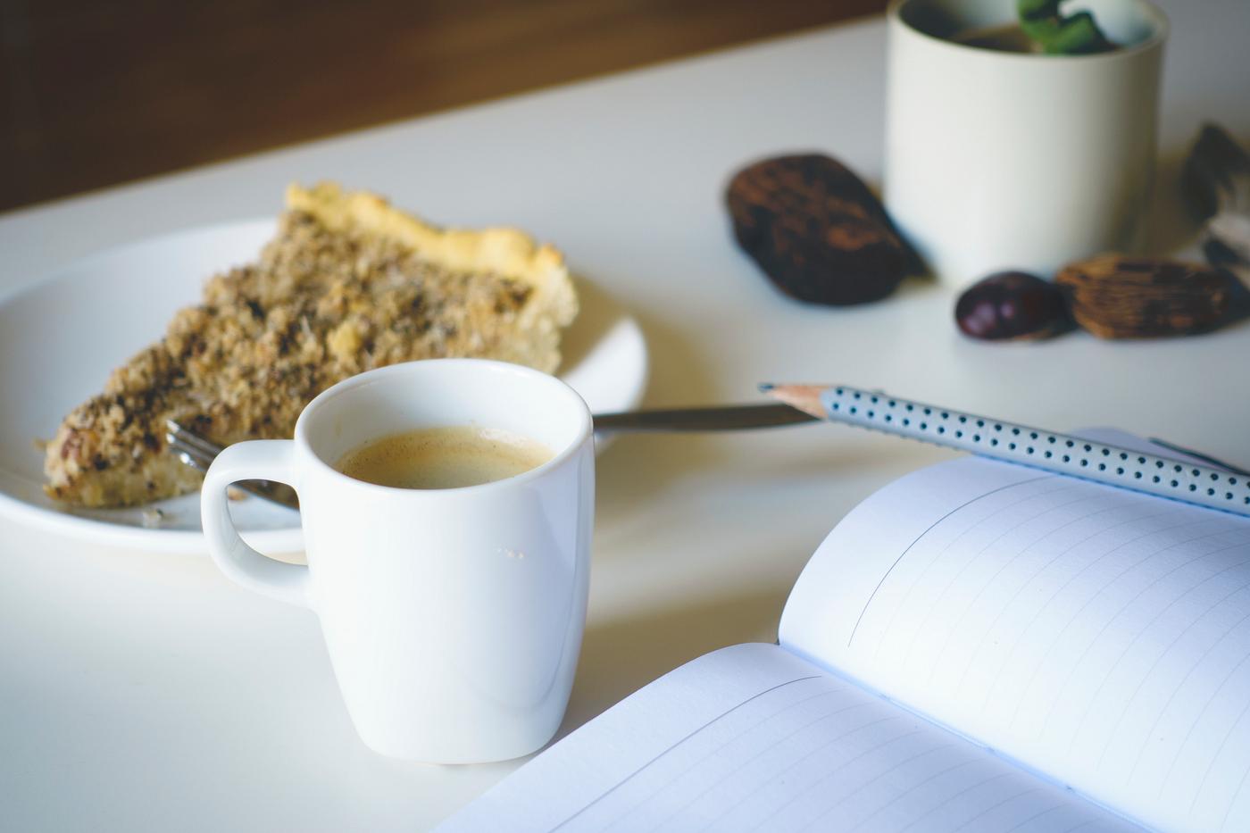 Writing a journal while having coffee and cake Writing a journal while having coffee and cake