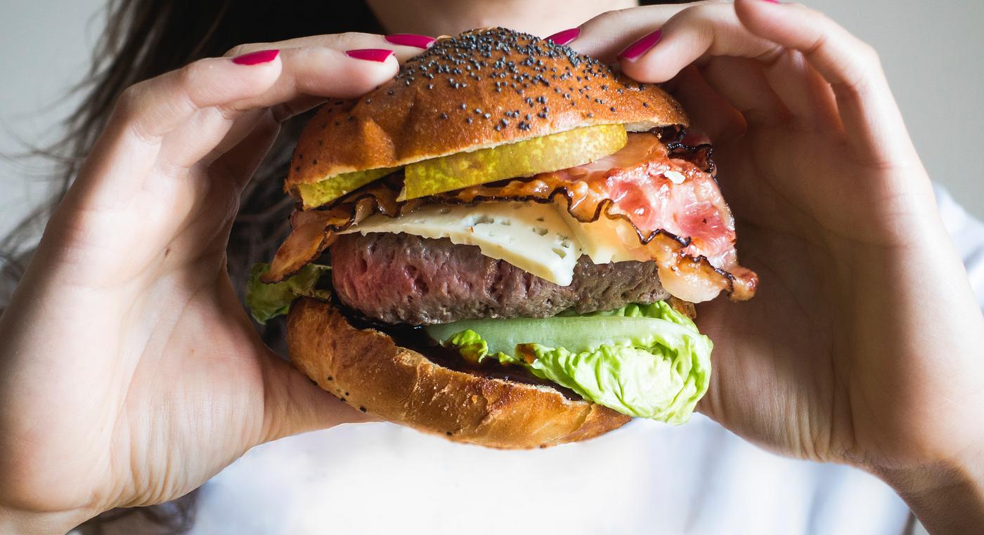 Woman holding a huge burger Woman holding a huge burger