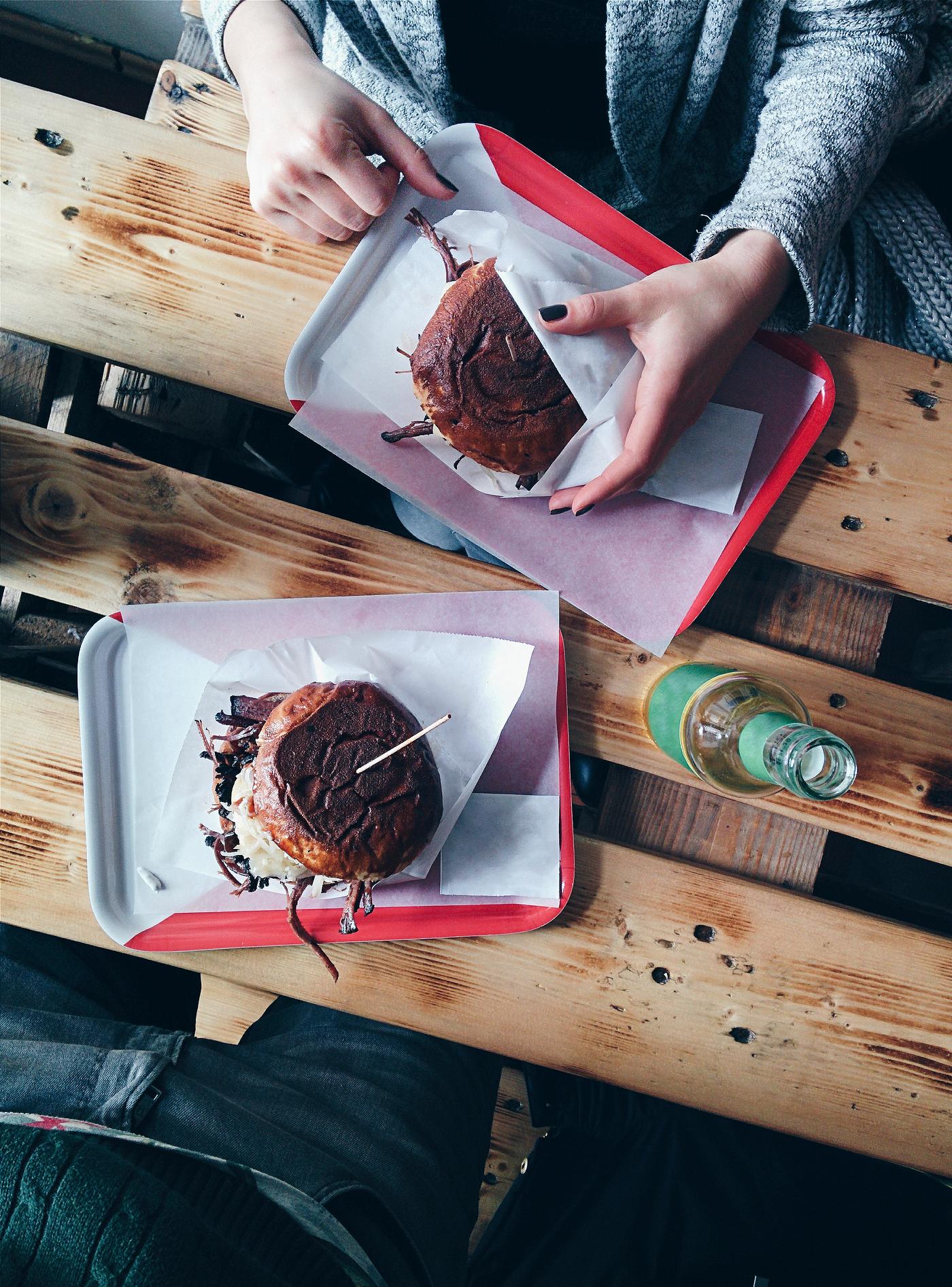 Hands holding pulled pork burger Hands holding pulled pork burger