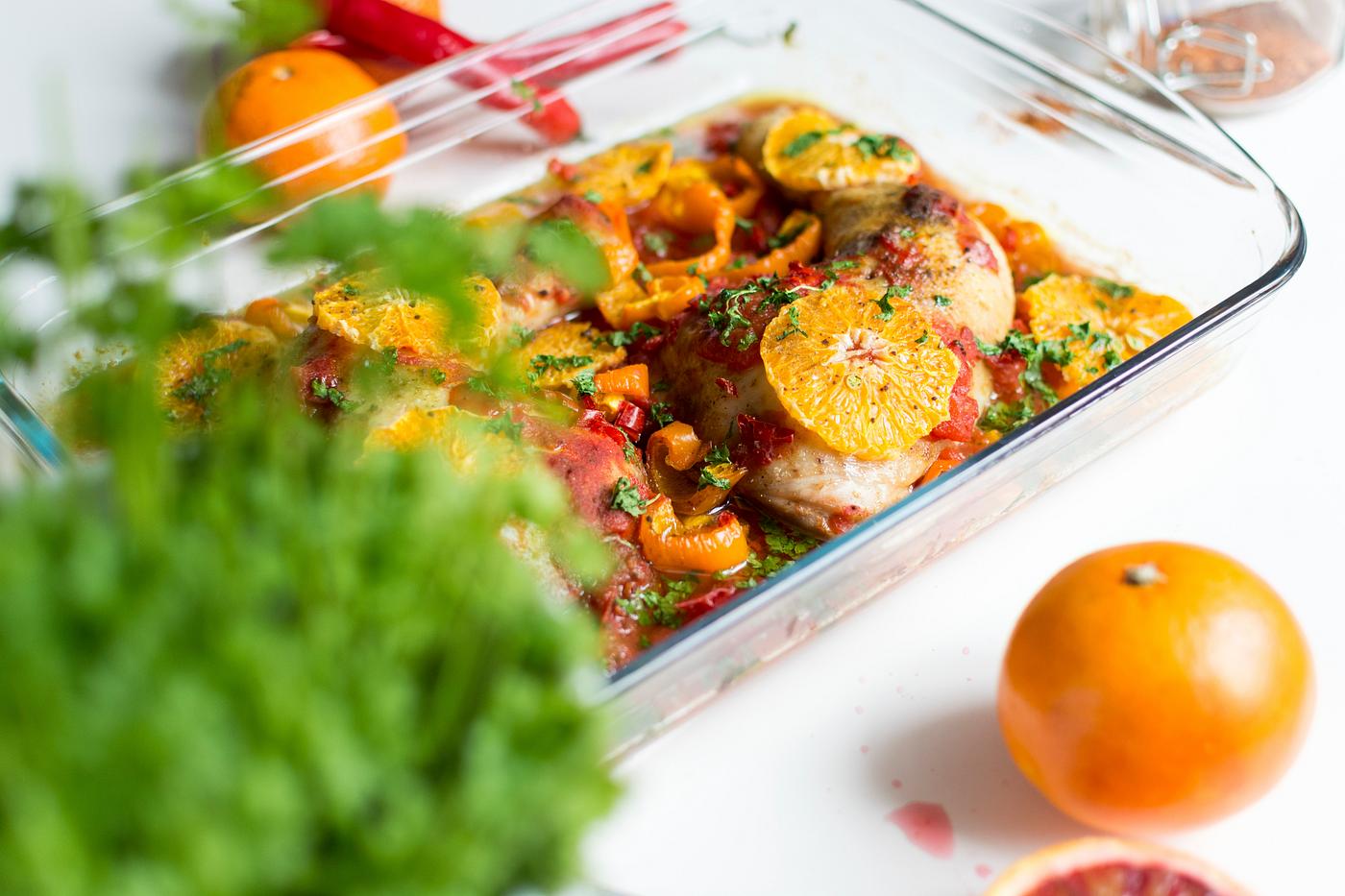 Chicken thighs with tomatoes, peppers, and oranges. Chicken thighs with tomatoes, peppers, and oranges.