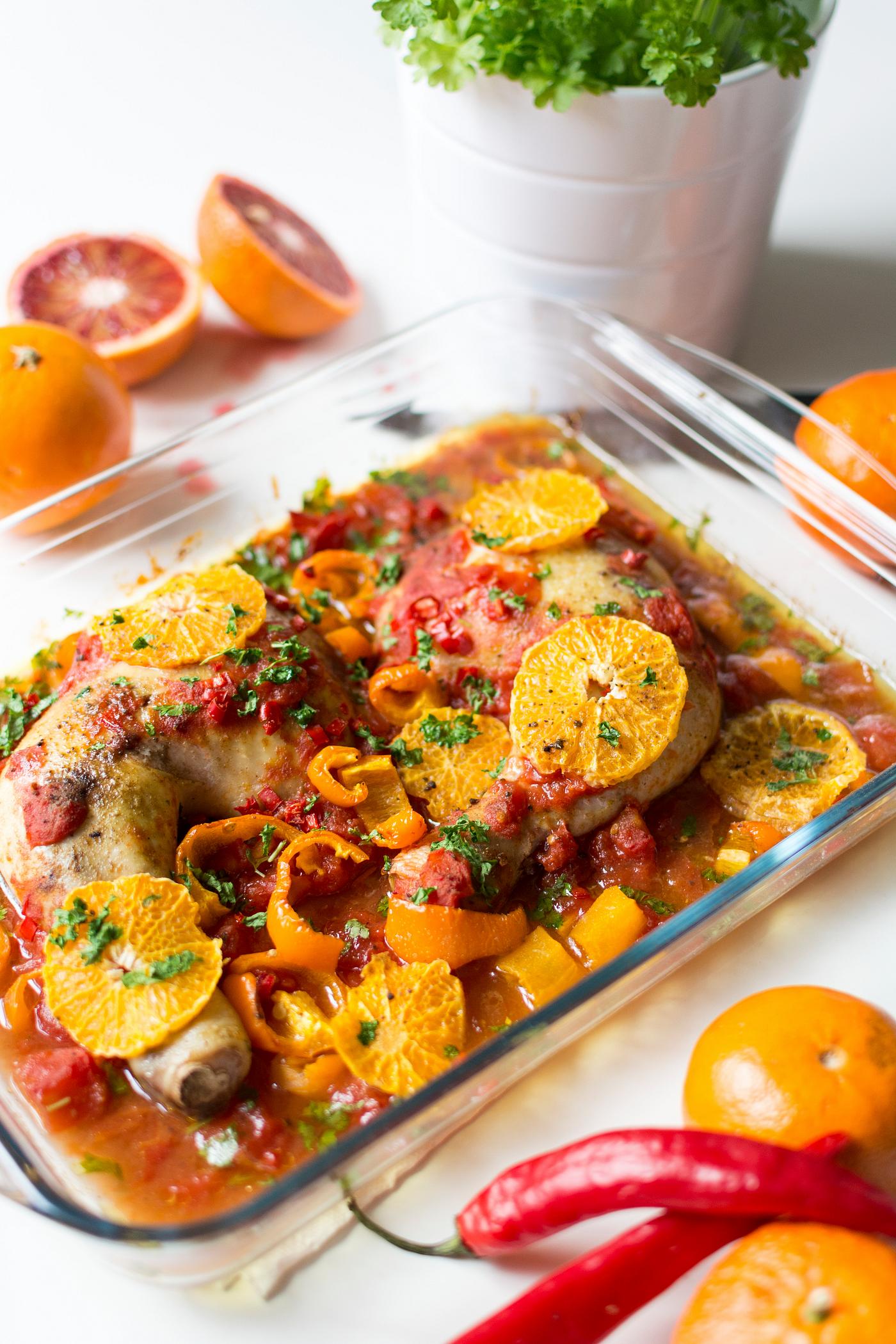 Chicken thighs with tomatoes, peppers, and oranges. Chicken thighs with tomatoes, peppers, and oranges.