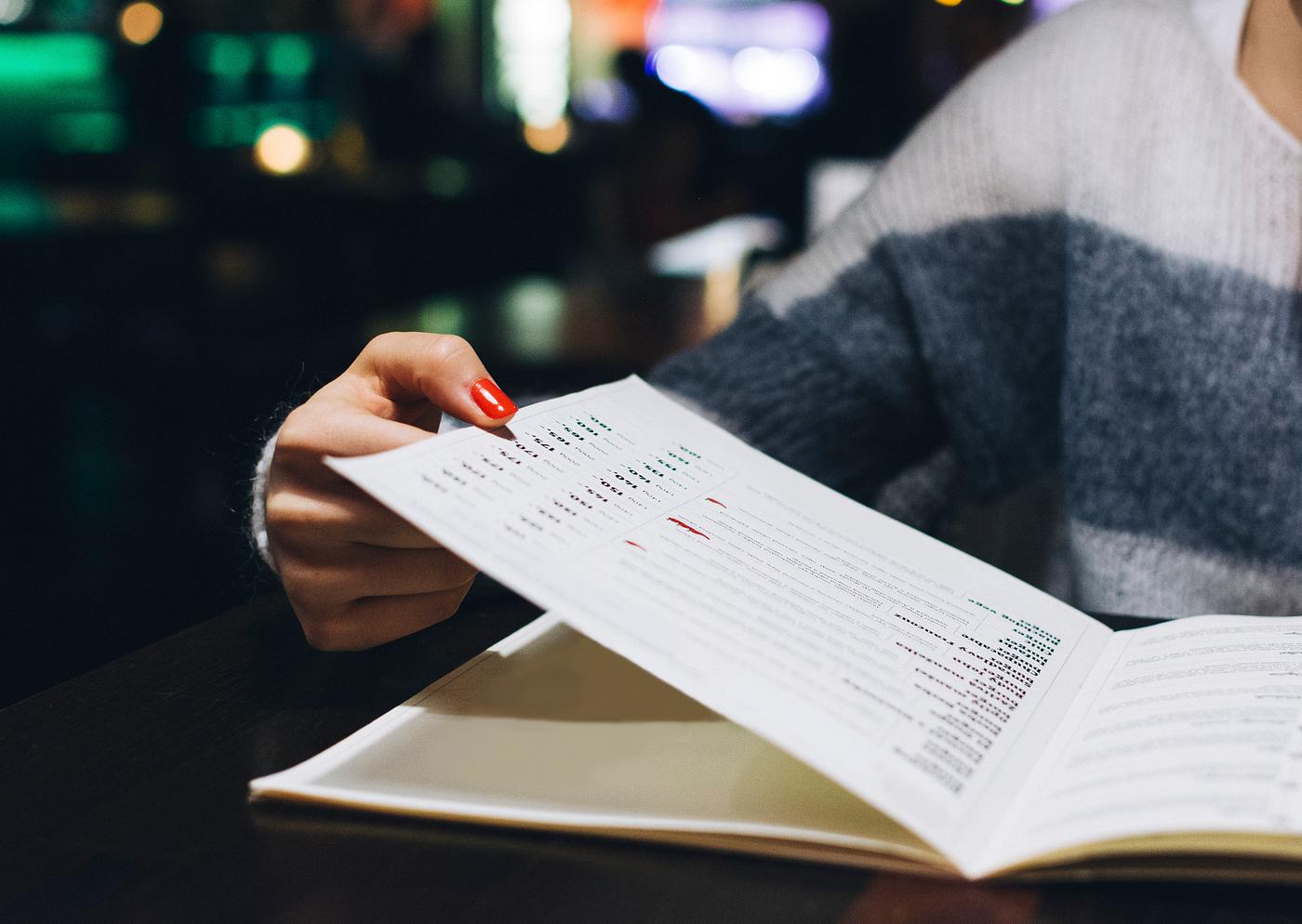 Person flipping through a menu Person flipping through a menu