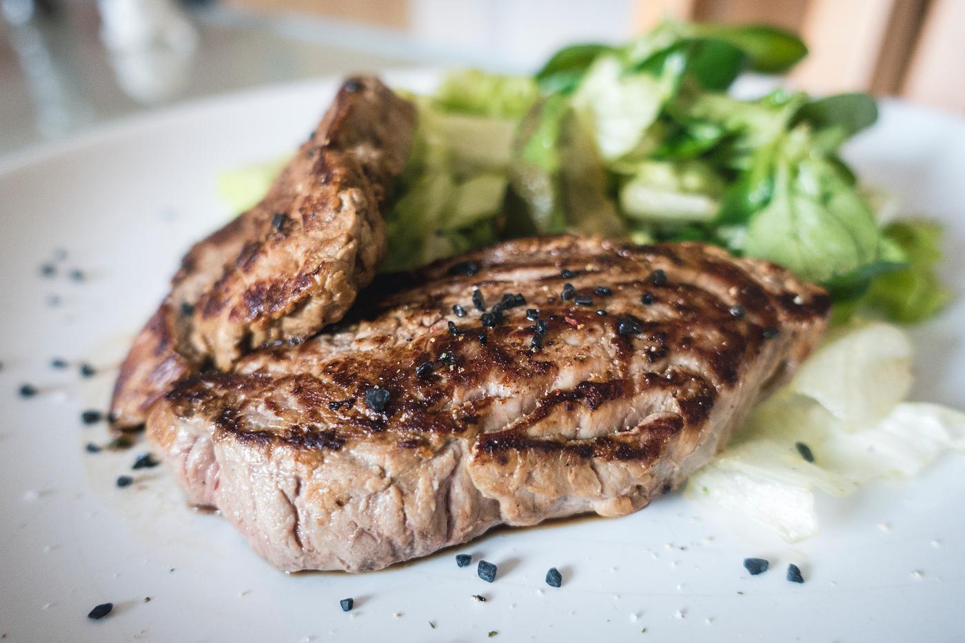 A beef steak with green salad closeup A beef steak with green salad closeup