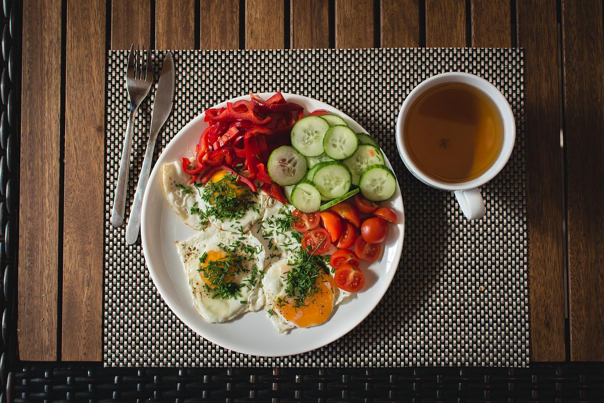 A beautifully arranged plate of Paleo breakfast with eggs, avocado, and bacon