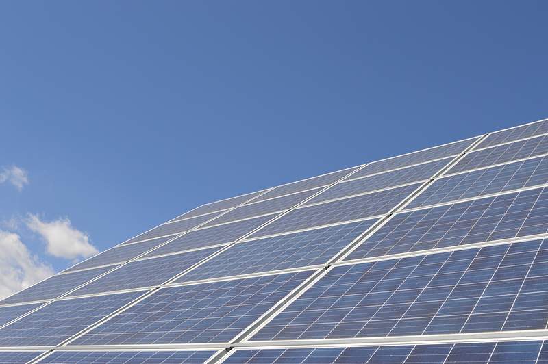Solar panels beneath a bright blue sky