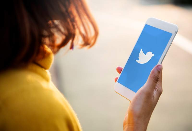 How Twitter Marketing Can Help Your Restaurant Business 2 Woman using Twitter on a phone