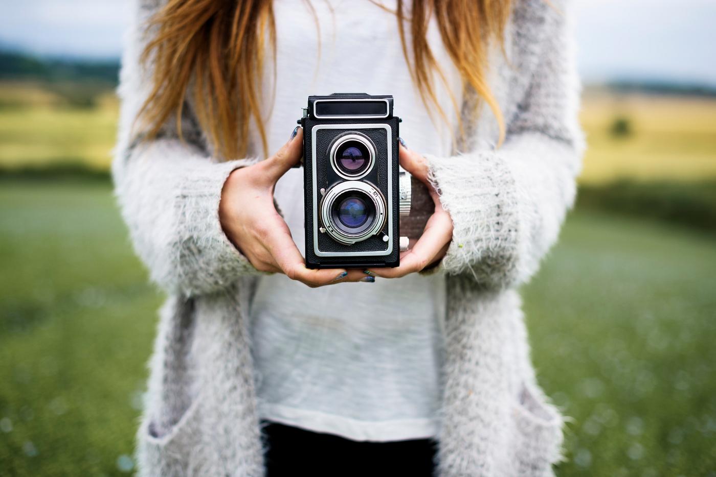 Woman holding retro film camera Woman holding retro film camera