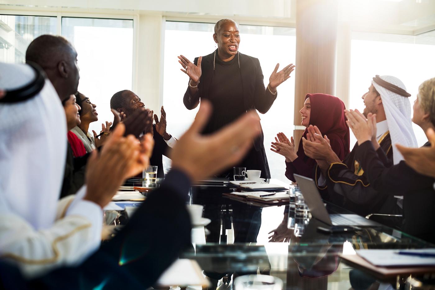 A Group of International Business People in a Meeting about Environment Clapping Their Hands A Group of International Business People in a Meeting about Environment Clapping Their Hands