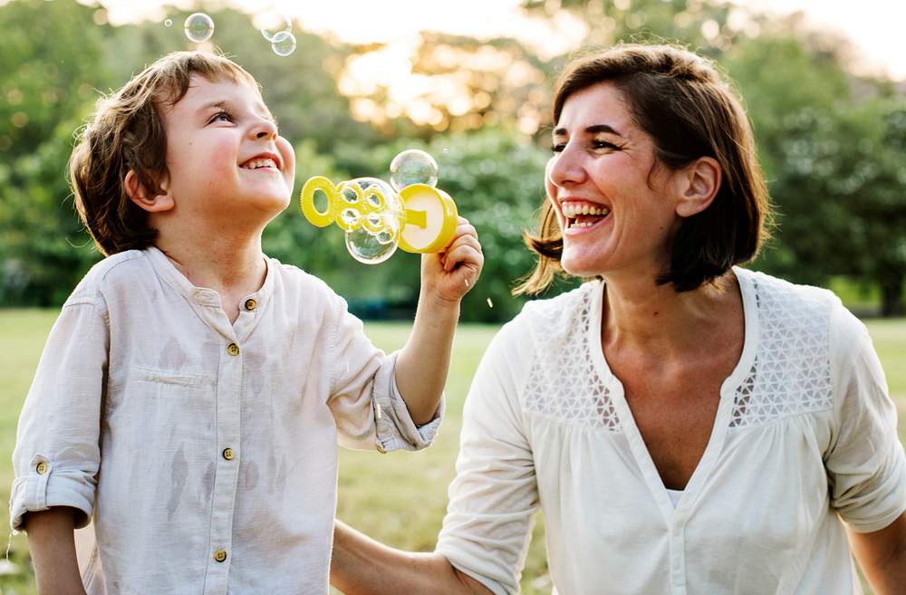 Teacher playing soap bubbles with her student