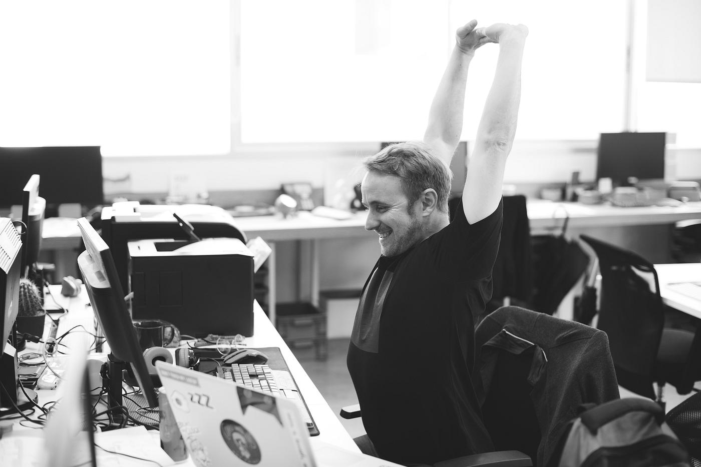 Man stretching arms during break time at office Man stretching arms during break time at office