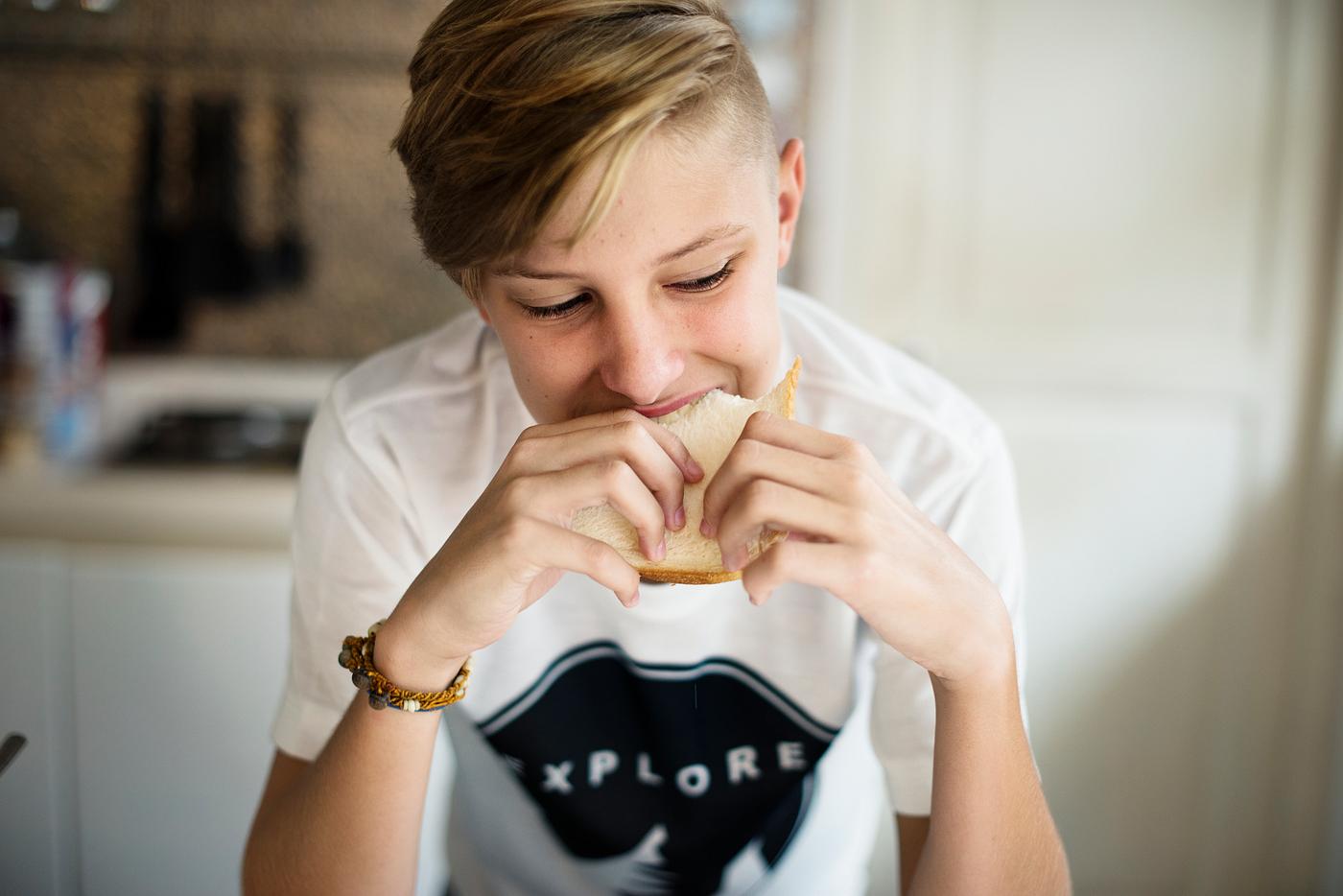 Young caucasian man eating sandwich in kitchen - sandwich, adolescence, alone, biting, boy, breakfast, caucasian, closeup,... Young caucasian man eating sandwich in kitchen - sandwich, adolescence, alone, biting, boy, breakfast, caucasian, closeup,...