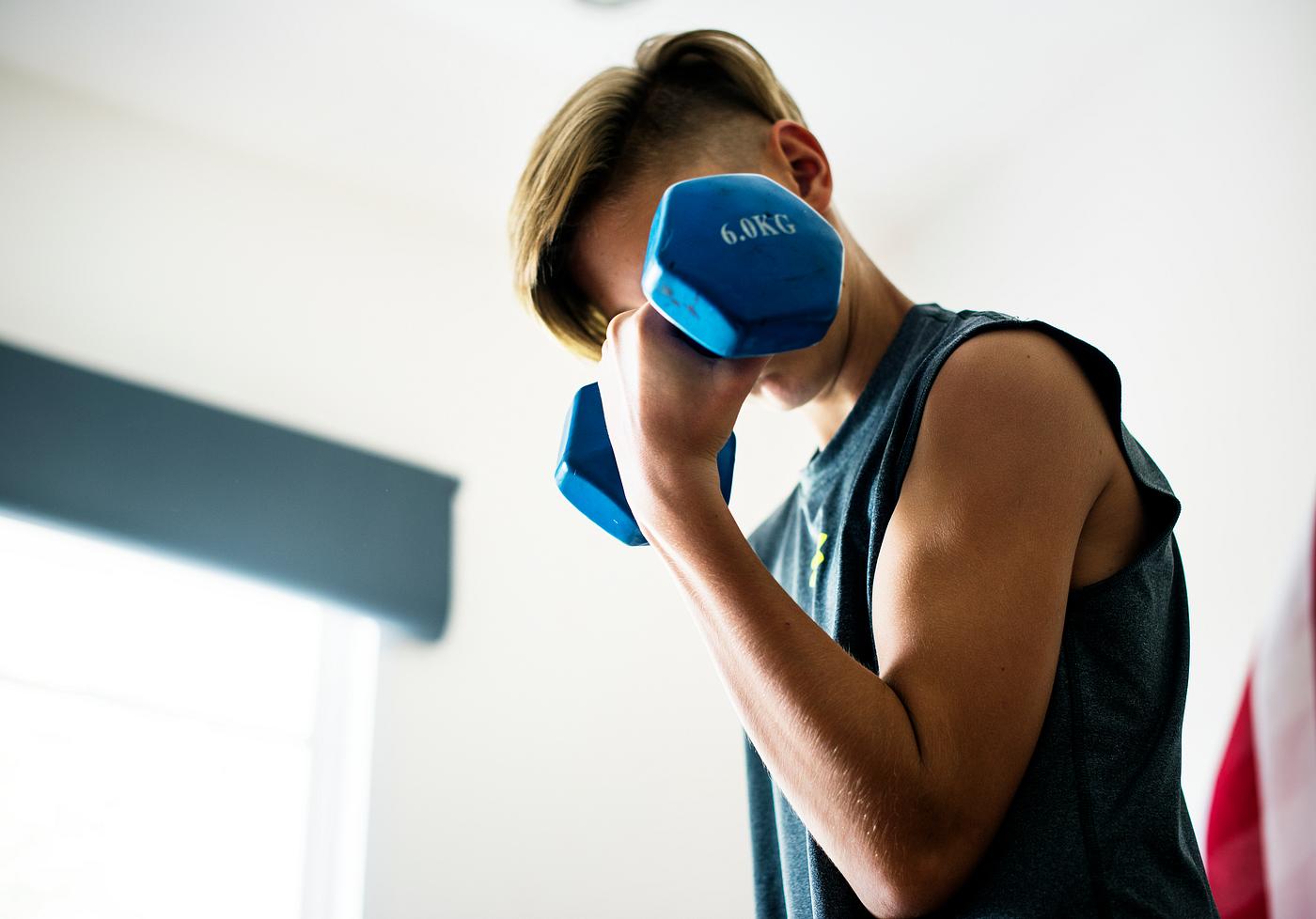 Young caucasian boy lifting dumbbell Young caucasian boy lifting dumbbell