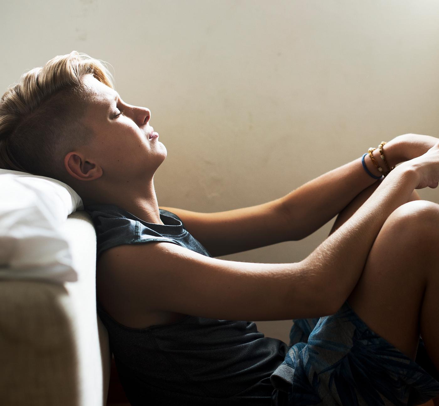 Closeup of young caucasian man sitting with face express of depressed upset emotion Closeup of young caucasian man sitting with face express of depressed upset emotion