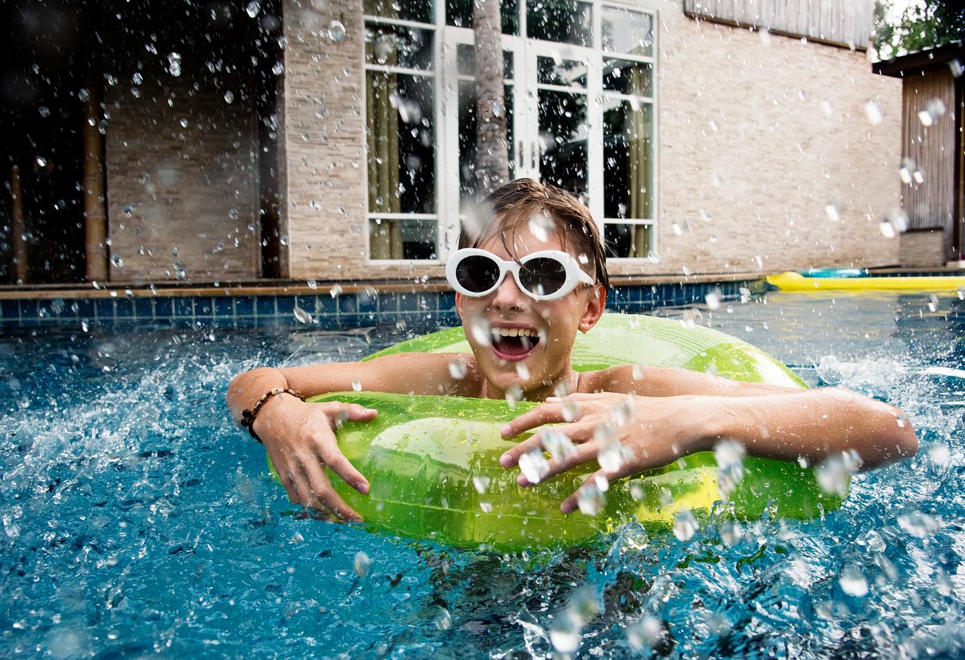 Young caucasian boy enjoying floating in the pool with tube Young caucasian boy enjoying floating in the pool with tube