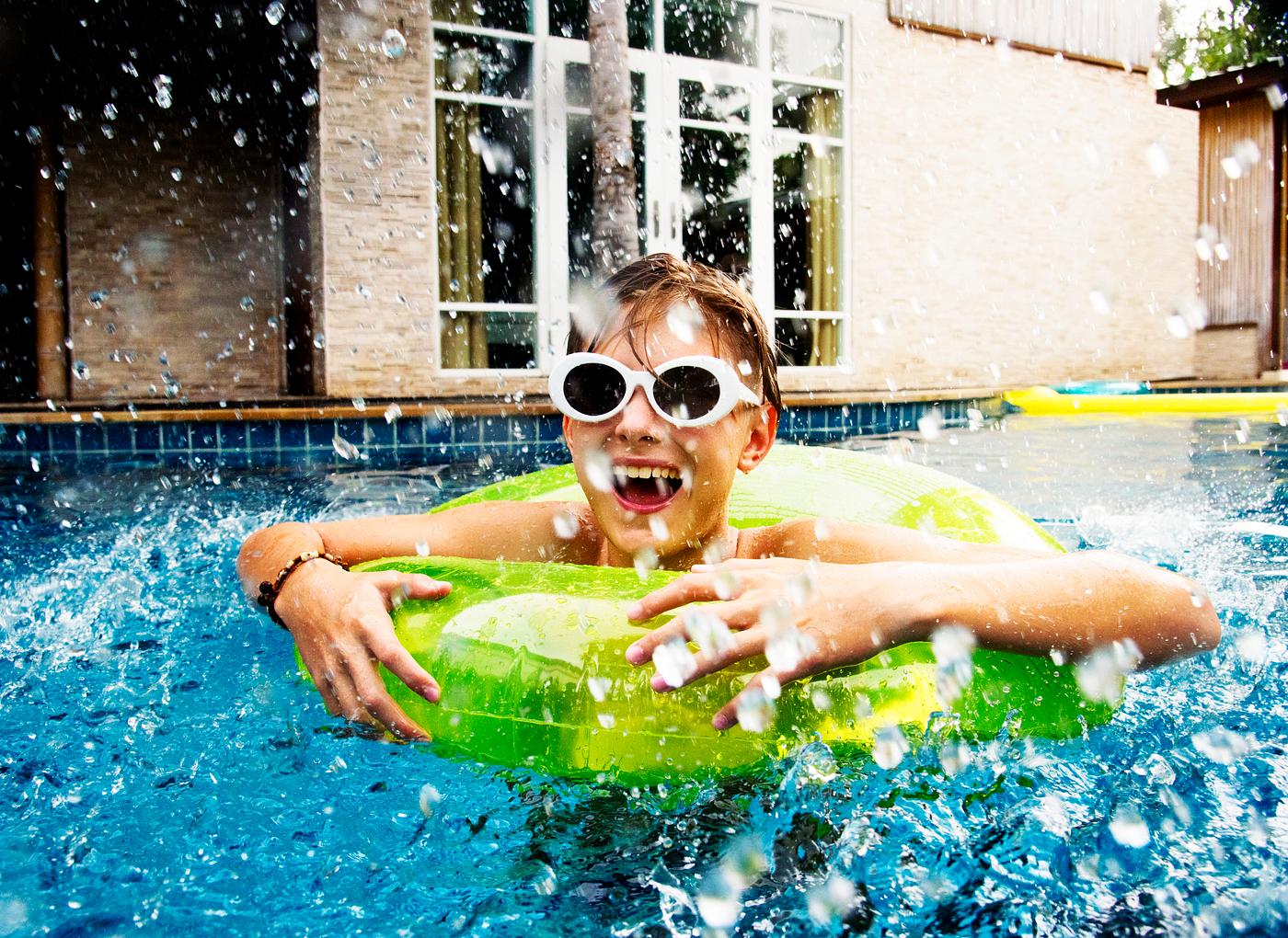 Young caucasian boy enjoying floating in the pool with tube Young caucasian boy enjoying floating in the pool with tube