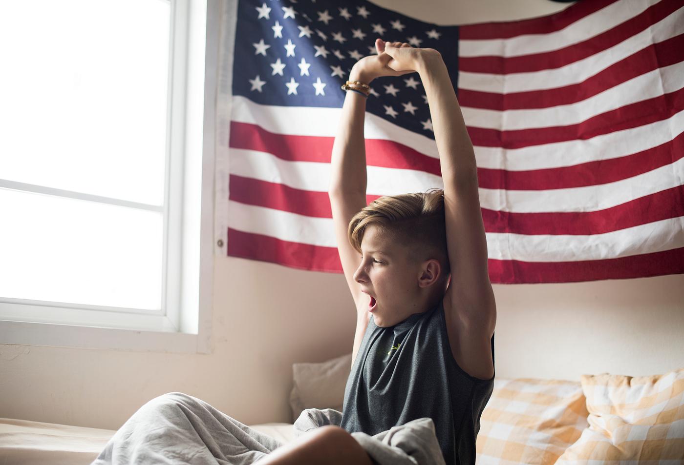 Young caucasian boy waking up stretching arms Young caucasian boy waking up stretching arms
