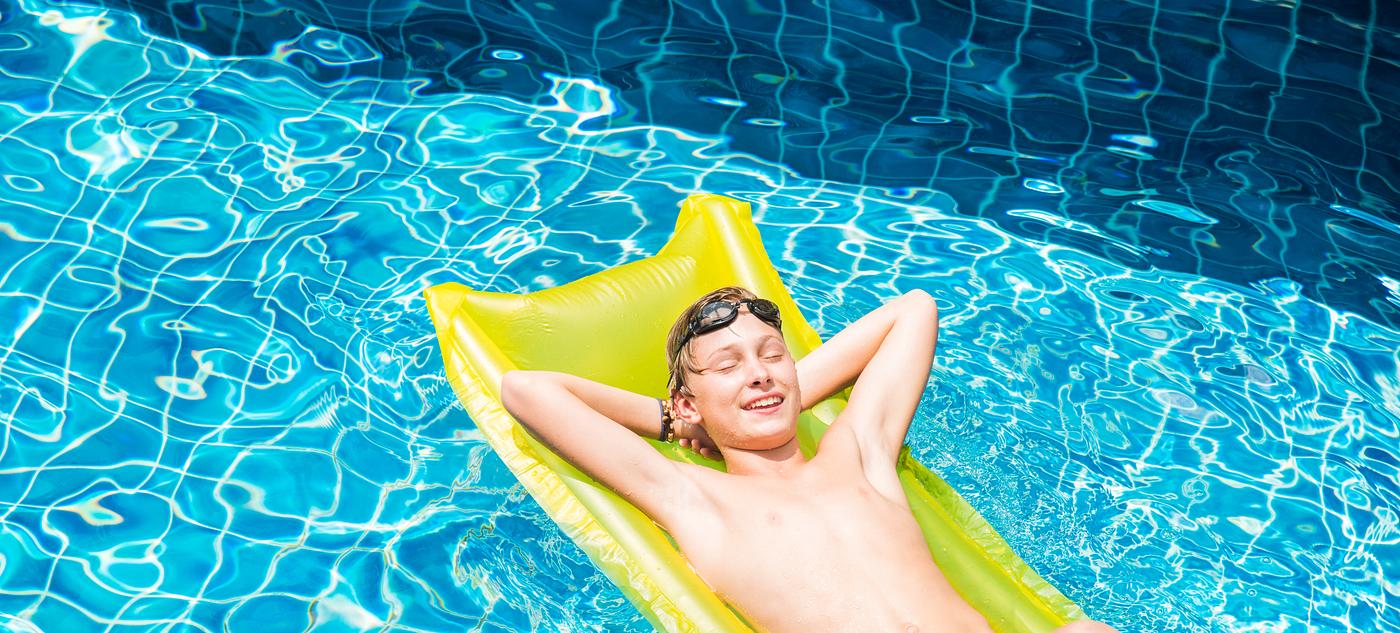 Teenage boy relaxing with pool mattress Teenage boy relaxing with pool mattress