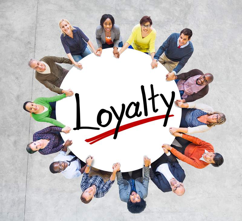 Group of People Holding Hands Around Letter Loyalty 