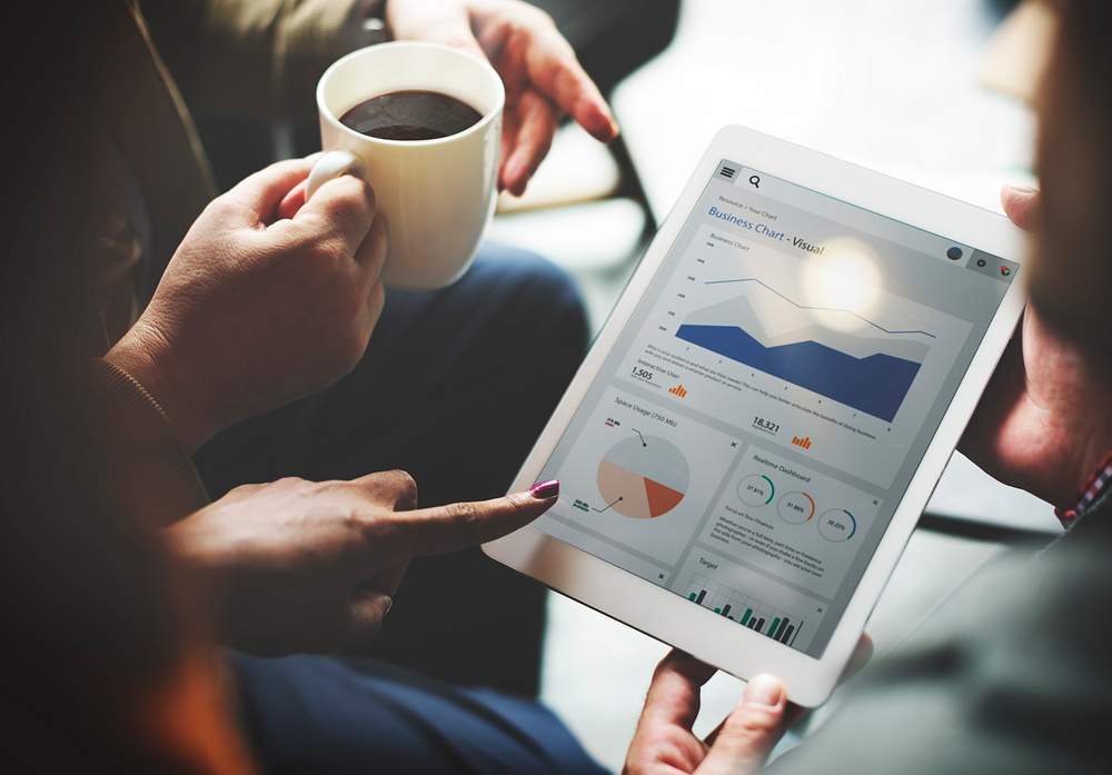 People analyzing charts and graphics from a tablet to represent data analytics in business