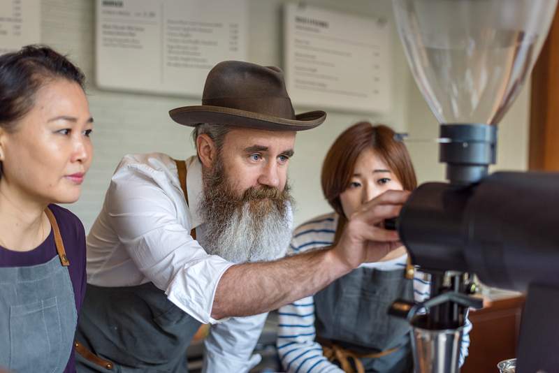 10 Essential Restaurant Manager Traits That Makes Them Exceptional 3 Barista teaching other baristas how to prepare a cup of coffee