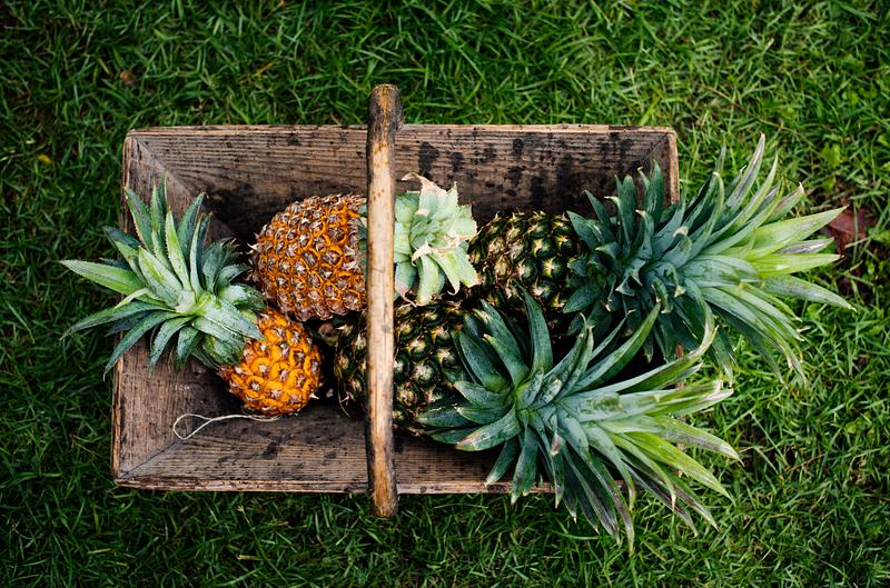 Pineapple harvest in a basket aerial, closeup, flat lay, flatlay