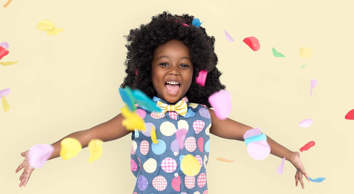 Girl with an afro enjoying colorful confetti Girl with an afro enjoying colorful confetti
