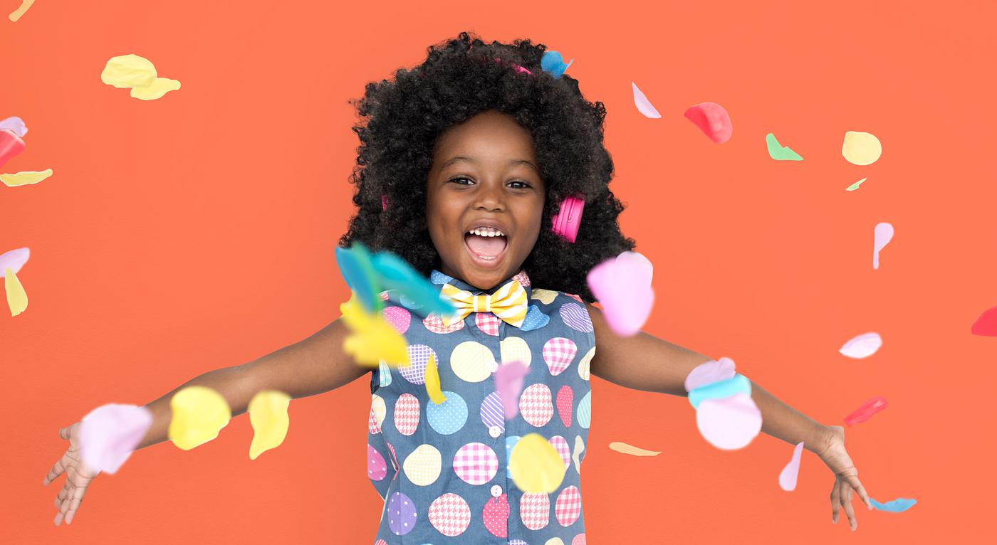 Girl with an afro enjoying colorful confetti Girl with an afro enjoying colorful confetti