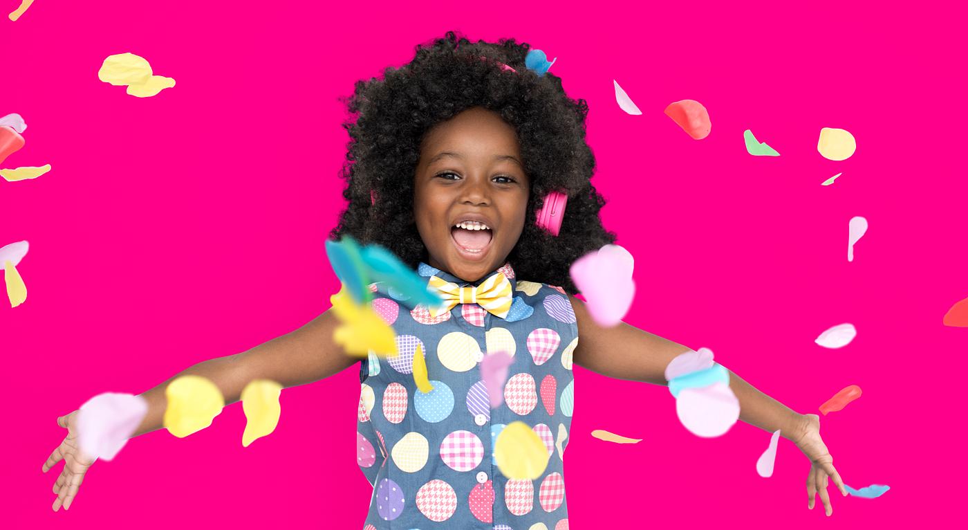 Girl with an afro enjoying colorful confetti Girl with an afro enjoying colorful confetti
