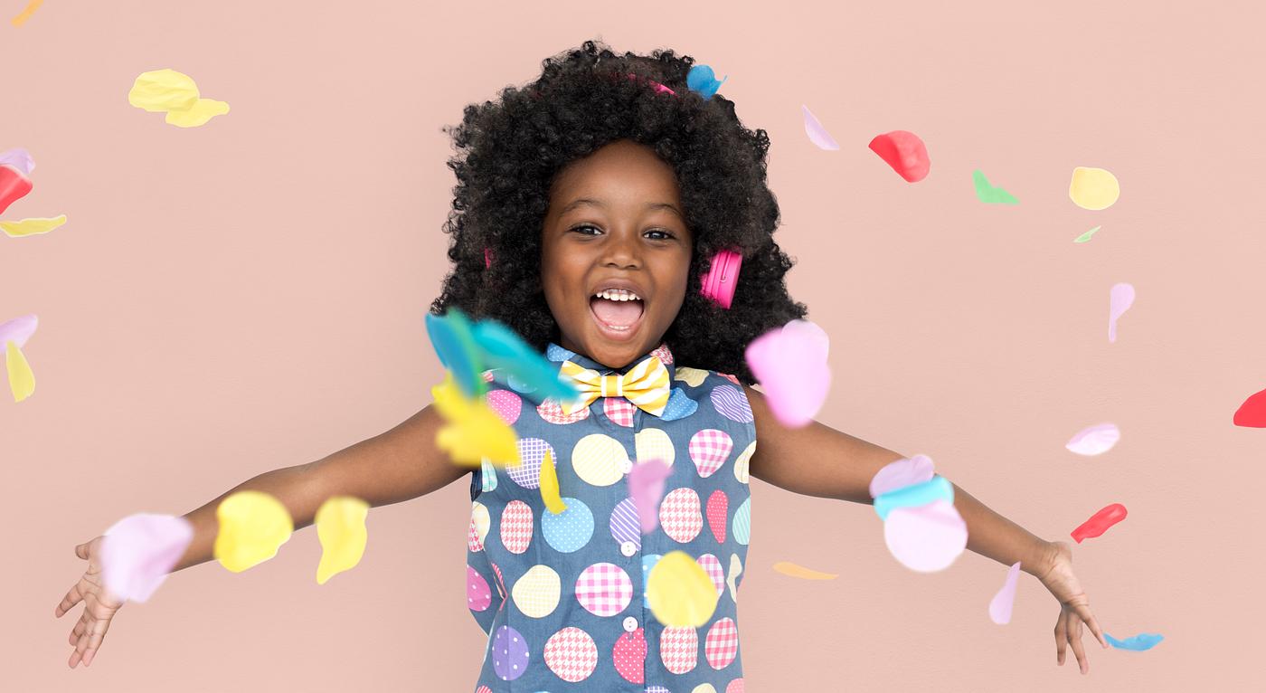 Girl with an afro enjoying colorful confetti Girl with an afro enjoying colorful confetti