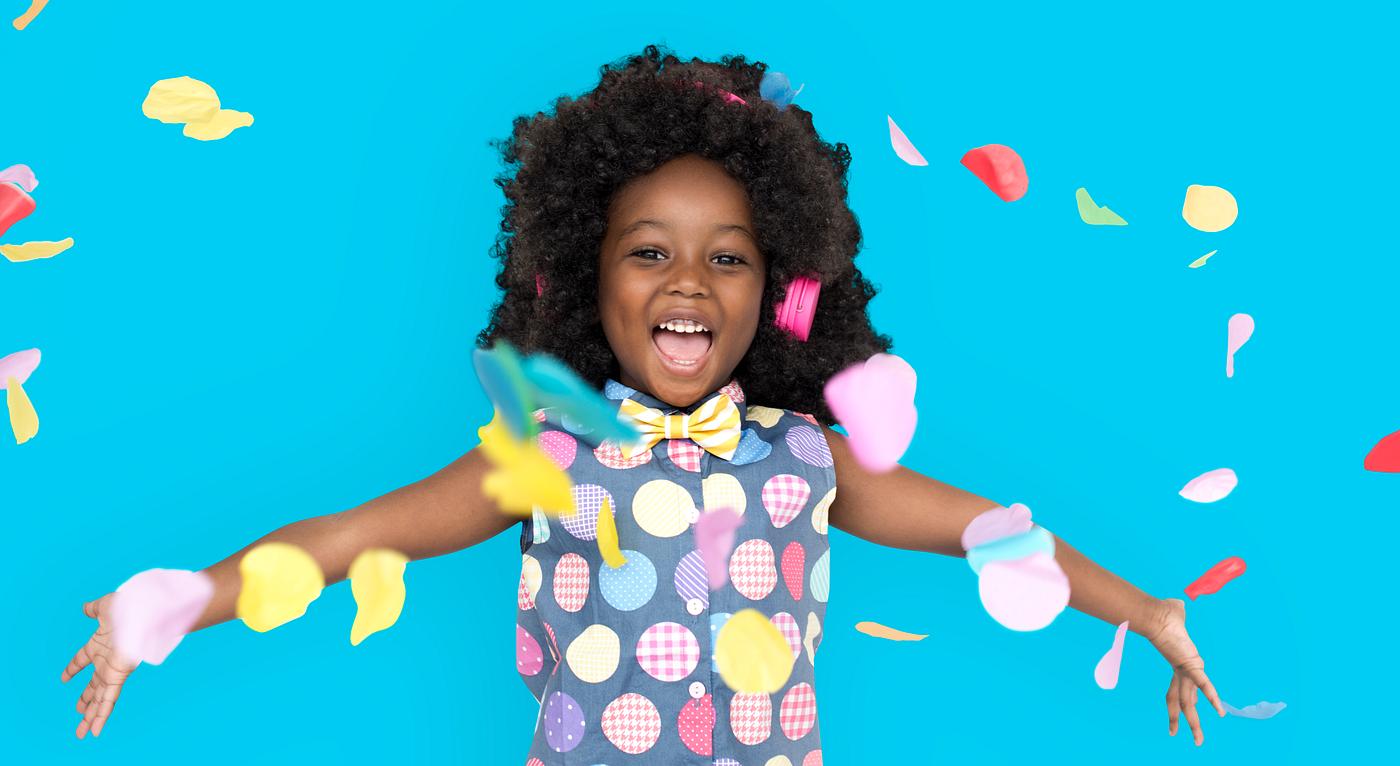 Girl with an afro enjoying colorful confetti Girl with an afro enjoying colorful confetti