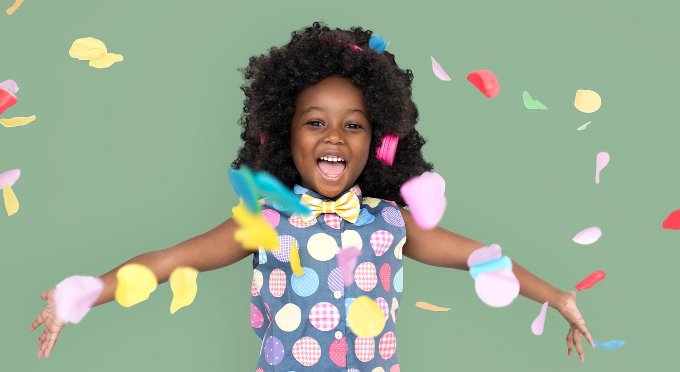 Girl with an afro enjoying colorful confetti Girl with an afro enjoying colorful confetti
