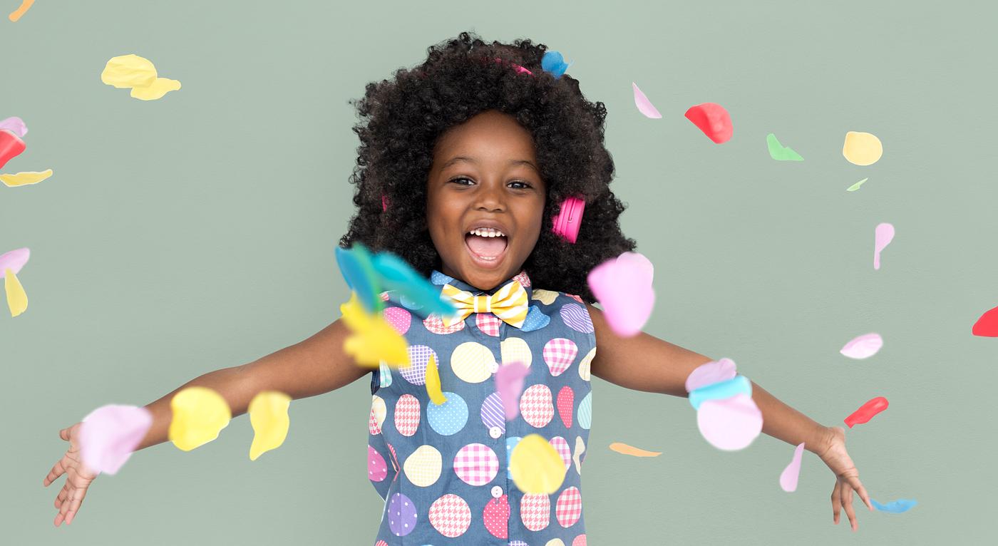Girl with an afro enjoying colorful confetti Girl with an afro enjoying colorful confetti