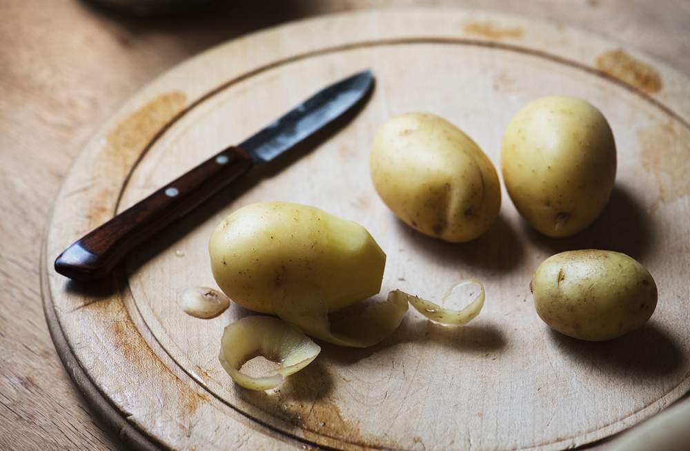Potatoes peeled on a cutting board 
